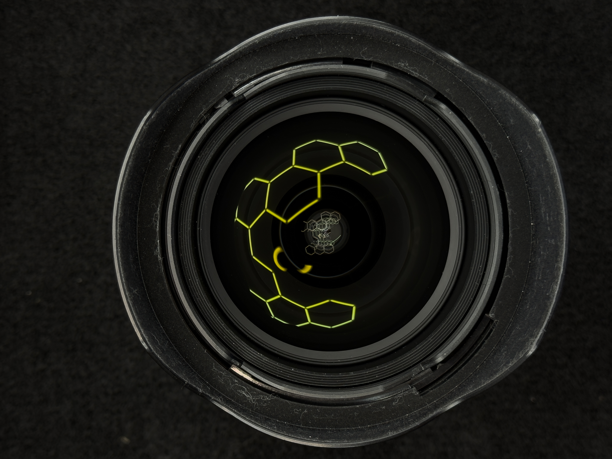Head-on look into the front element of the Nikon Z 14-24mm f/2.8 S to display the constant f/2.8 physical glass opening and the 9 rounded diaphragm blades