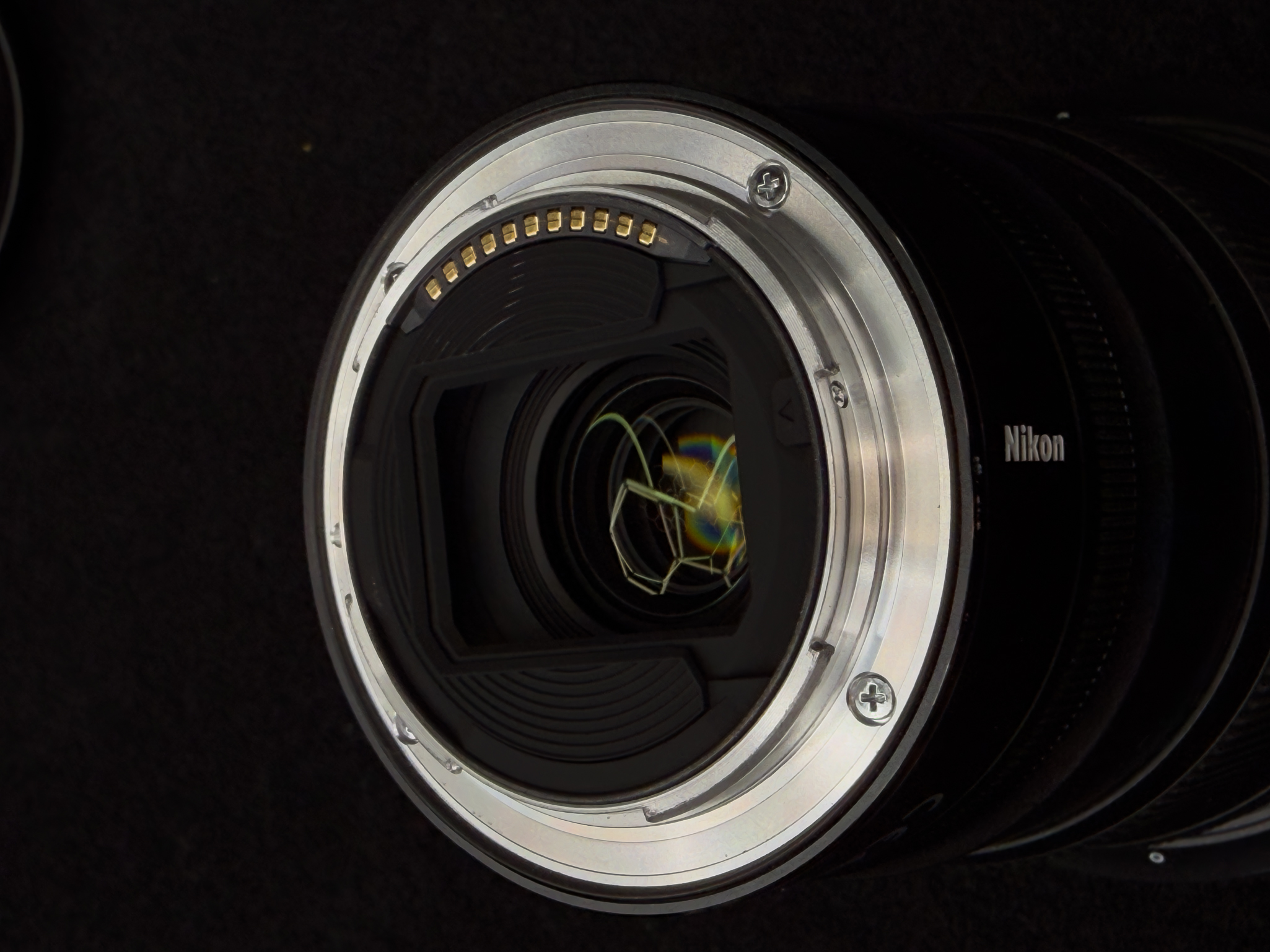 Close-up focusing directly on the thin black rubber weather-sealing gasket lining the outer rim of the rear metal mount on the Nikon Z 14-24mm f/2.8 S