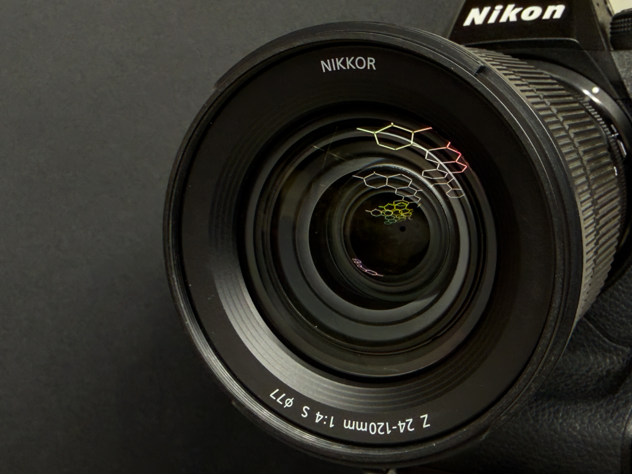 Head-on look into the large front element of the Nikon Z 24-120mm f/4 S to display the 9-blade rounded aperture mechanism