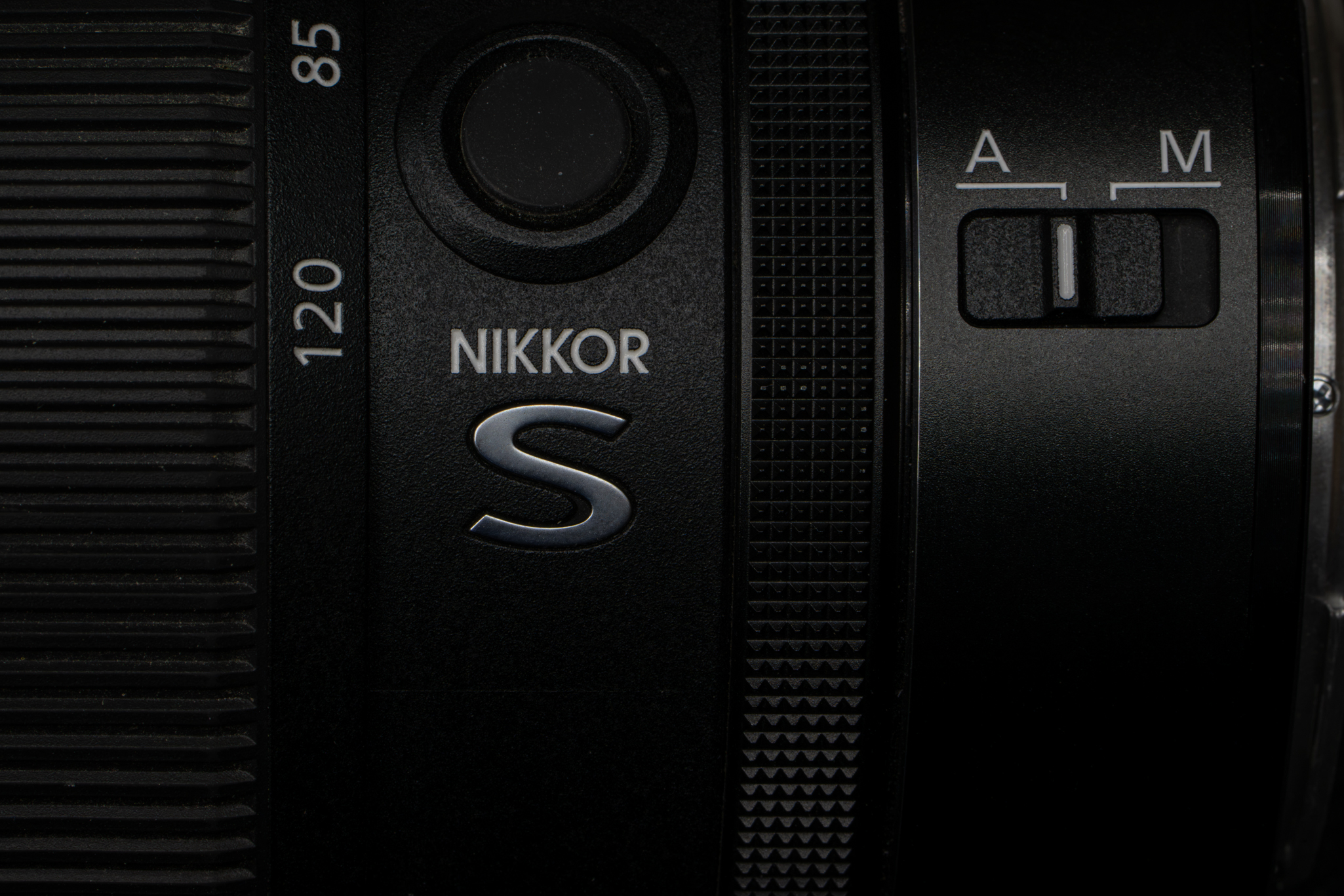 Close-up highlighting the iconic silver metallic 'S' line badge on the side of the Nikon Z 24-120mm f/4 S, emphasizing its premium tier placement